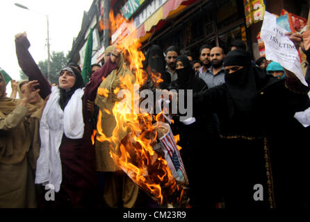 Sett. 17, 2012 - Srinagar Kashmir, India - Un attivista velato da Jammu Kashmir Khawateen musulmano campo Markaz (MKM) partito brucia una bandiera americana durante una manifestazione di protesta contro la "l'innocenza di musulmani,' un internet video considerano blasfema all Islam. (Credito Immagine: © Altaf Zargar/ZUMAPRESS.com) Foto Stock