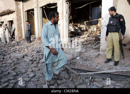 Il personale addetto alla sicurezza e le persone si radunano presso il sito dopo l esplosione di bomba a Kohat Road a Peshawar Mercoledì, 19 settembre 2012. Almeno otto persone sono state uccise altre sono state subito lesioni quando un materiale esplosivo piantato in una vettura blew up vicino a regime Chowk Foto Stock