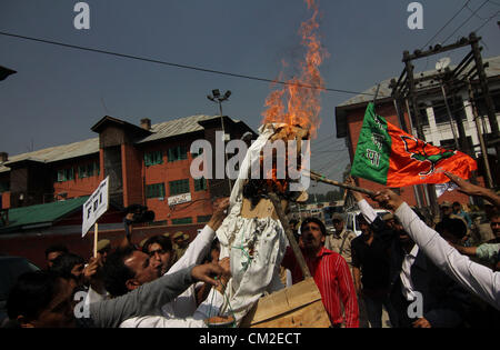 Sett. 20, 2012 - India del principale partito d opposizione Bartaya Janta Party (BJP) attivisti masterizzare un'effigie della incombente governo UPA durante una manifestazione di protesta a Srinagar la capitale estiva del Kashmir indiano. I partiti di opposizione e i sindacati chiamato per i negozianti, di commercianti e di lavoratori in India per bloccare le linee ferroviarie e chiudere i mercati per protestare contro le riforme, progettato dal Primo Ministro Manmohan Singh, ravvivare India del rallentamento economico consentendo nel retail stranieri giganti come Walmart e Tesco. Foto Stock