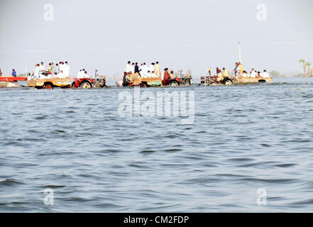 Colpite dalle alluvioni la gente si sposta verso il luogo sicuro dopo l'alluvione accumulata nelle loro case durante la pioggia pesante nella stagione dei monsoni a Jacobabad giovedì, 20 Settembre 2012 Foto Stock