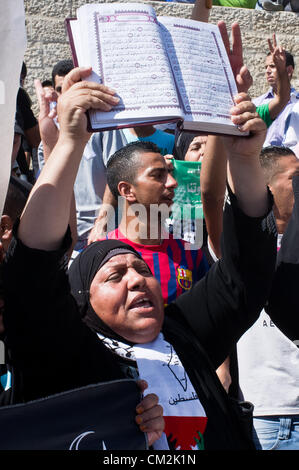 Una donna di contenimento e la visualizzazione di un Corano grida slogan contro gli Stati Uniti e Israele per presunto scortesi a insultare i musulmani con "l'innocenza di musulmani' filmato. Gerusalemme, Israele. 21-Settembre-2012. Migliaia di adoratori di Al-Aqsa disperdere tranquillamente dopo la preghiera del Venerdì attraverso la porta di Damasco. Un piccolo gruppo di un centinaio di fase di un simbolico, dieci minuti, protesta contro "l'innocenza di musulmani' insulto filmato Muhammad e seguaci. Foto Stock