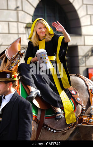 Monaco di Baviera, Germania. 23 Settembre, 2012. La parata di apertura dei più grandi del mondo di birra-festival, Oktoberfest, procede attraverso la città di Monaco di Baviera, Germania. La ragazza Maria Newrzella, vestita nei colori di Monaco di Baviera con un boccale di birra, rappresenta il simbolico talismano per Monaco di Baviera e faceva parte del 8900 i partecipanti di questo pubblico parade. Foto Stock