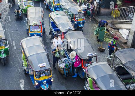 Sett. 26, 2012 - Bangkok, Thailandia - Tuk-tuks (tre ruote taxi) attendere per tariffe in corrispondenza di una uscita di Khlong Toey Mercato in Bangkok. Khlong Toey (chiamato anche Khlong Toei) Market è uno dei più grandi '"wet mercati'' in Thailandia. Il mercato è situato nel bel mezzo di uno di Bangkok la più grande delle aree povere e vicino alla città in originale di deep water port. Migliaia di persone vivono nella vicina baraccopoli zona. Più di un migliaio di shop nella tentacolare Mercato di frutta fresca e verdura e carne, pesce e pollame. (Credito Immagine: © Jack Kurtz/ZUMAPRESS.com) Foto Stock