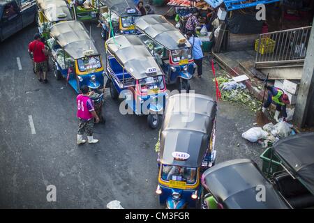 Sett. 26, 2012 - Bangkok, Thailandia - Tuk-tuks (tre ruote taxi) attendere per tariffe in corrispondenza di una uscita di Khlong Toey Mercato in Bangkok. Khlong Toey (chiamato anche Khlong Toei) Market è uno dei più grandi '"wet mercati'' in Thailandia. Il mercato è situato nel bel mezzo di uno di Bangkok la più grande delle aree povere e vicino alla città in originale di deep water port. Migliaia di persone vivono nella vicina baraccopoli zona. Più di un migliaio di shop nella tentacolare Mercato di frutta fresca e verdura e carne, pesce e pollame. (Credito Immagine: © Jack Kurtz/ZUMAPRESS.com) Foto Stock