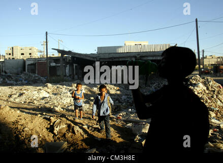 Sett. 26, 2012, a Rafah nella striscia di Gaza, Territori palestinesi - bambini palestinesi stare vicino ad un eruzione pipeline di liquame in Rafah Refugee Camp sud della striscia di Gaza, Settembre 26, 2012. In seguito agli avvenimenti del militare israeliano operazione piombo fuso nel 2008/2009, i rifugiati palestinesi nei campi profughi di Gaza hanno bisogno di maggiore sostegno per la ricostruzione di Gaza, di promuovere la ripresa economica e l'indirizzo a lungo termine delle esigenze di sviluppo, comprese le infrastrutture (credito Immagine: © Eyad Al Baba APA/images/ZUMAPRESS.com) Foto Stock