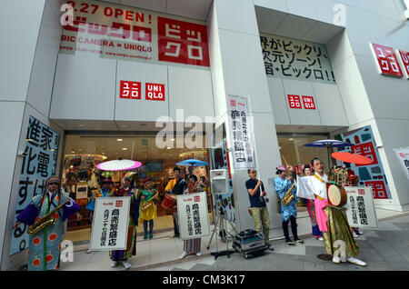 Settembre 27, 2012, Tokyo, Giappone - un fumetto in costume della banda musicale allieta l'atmosfera per la grande apertura di BicQlo, una collaborazione di abbigliamento casual rivenditore Uniqlo e consumer electronics catena Bic fotocamera, a loro flagship store di Tokyo del quartiere di Shinjuku giovedì, 27 settembre 2012. BicQlo è nato dalla collaborazione tra i due giganti di rivenditori che hanno messo insieme le loro rispettive know-how in moda e di elettronica di consumo e il nuovo flagship store. L'uscita nel mezzo di Shinjuku la zona commerciale si vendono i più recenti e i prodotti più diffusi, I bests hanno andato del Foto Stock