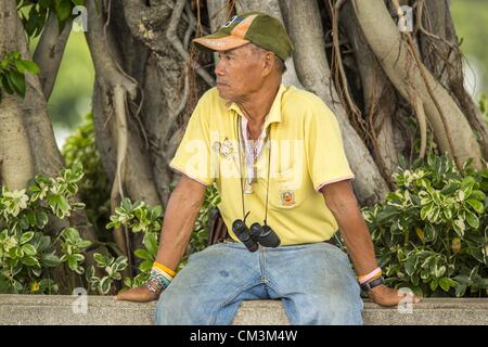 Sett. 27, 2012 - Bangkok, Thailandia - Thai un uomo che indossa una maglietta gialla attende per la prova del Royal Barge Processione per raggiungere Tha Tien Pier a Bangkok. Thais frequentemente giallo di usura in occasione di eventi legati alla famiglia reale perché il giallo è considerato il re di colore. Il Thai Royal Barge processione è una cerimonia di entrambi i religiosi e significato reale che risale a quasi 700 anni. Il Royal Barge processione avviene raramente, tipicamente coincidente con solo i più significativi eventi culturali e religiosi. Questo anno ci sarà una piena processione il 9 novembre per contrassegnare la fine di Budd Foto Stock