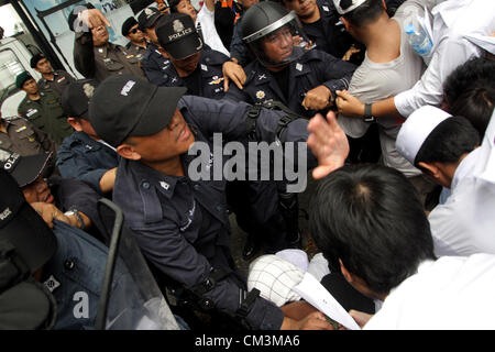 Sett. 27, 2012 - Bangkok, Tailandia. Manifestanti musulmani azzuffa con poliziotti durante una manifestazione di protesta. Più di 300 manifestanti musulmani protestare contro l'anti-Islam film 'L'innocenza dei musulmani' fuori dall'ambasciata degli Stati Uniti prima di passare a Google Inc. Thailandia, al Central World Shopping Mall per chiedere la rimozione della pellicola da Youtube. Foto Stock