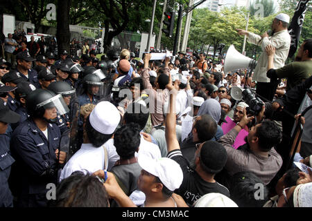 Sett. 27, 2012 - Bangkok, Tailandia. Manifestanti musulmani azzuffa con poliziotti durante una manifestazione di protesta. Più di 300 manifestanti musulmani protestare contro l'anti-Islam film 'L'innocenza dei musulmani' fuori dall'ambasciata degli Stati Uniti prima di passare a Google Inc. Thailandia, al Central World Shopping Mall per chiedere la rimozione della pellicola da Youtube. Foto Stock