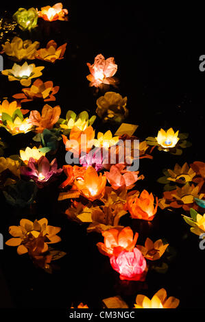 Carta fiori di loto con candele galleggiante sulle rive di un fiume di notte per contrassegnare i cinesi Mid-Autumn Festival Foto Stock