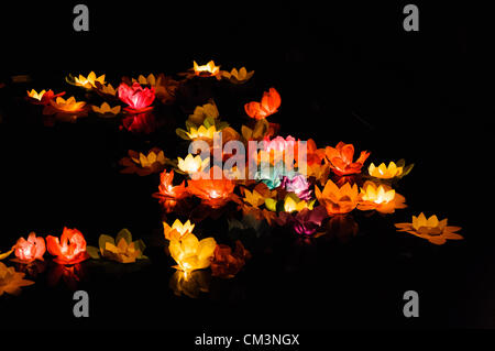 Carta fiori di loto con candele galleggiante sulle rive di un fiume di notte per contrassegnare i cinesi Mid-Autumn Festival Foto Stock