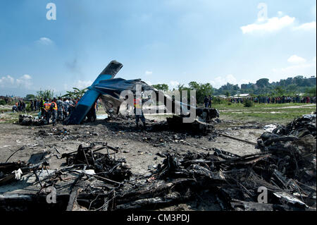 Sett. 28, 2012 - Kathmandu, Kathmandu, Nepal - Nepal una poliziotti stand intorno al relitto dell'aria sita in aereo presso il sito del crash. Un piano di trasporto del trekking nella regione dell Everest si è schiantato poco dopo il decollo del venerdì mattina in Nepal il capitale, uccidendo tutti 19 persone a bordo. Le vittime sono sette inglesi, cinque cinesi e quattro il nepalese. La doppia elica del motore aereo appartenenti al mercato domestico Sita Air si è schiantato sul terreno aperto vicino al fiume Manohara sul bordo sudoccidentale di Katmandu. La mattina il tempo era chiaro. L'autunno è il picco stagionale del turismo in Nepal. Foto Stock