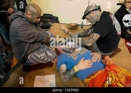 Il 28 settembre 2012, Londra, Regno Unito. L'ottava London Tattoo Convention inizia oggi al Dock di tabacco nell'East End di Londra. Tattooists e tatuaggio di appassionati provenienti da tutto il mondo affluiscono alla sede. Tradizionali mano-maschiatura tatuaggio dall Indonesia. Foto Stock