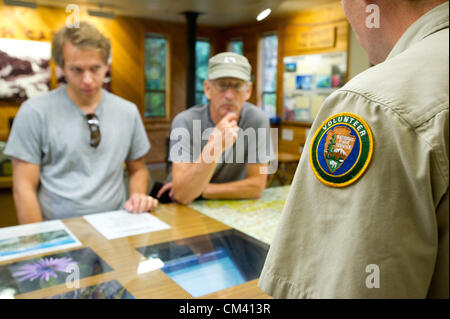 Agosto 28, 2012 - Marblemount, Washington, Stati Uniti d'America - 28 agosto 2012, Marblemount, Washington - Camper ottieni un aggiornamento sulle condizioni di backcountry da un parco volontario presso il deserto Information Center in Marblemount. Camper nel Parco Nazionale delle Cascate del Nord sono rilasciati permessi di backcountry presso il sito dove essi possono anche imparare circa il percorso e le condizioni atmosferiche. (Credito Immagine: © David Snyder/ZUMAPRESS.com) Foto Stock