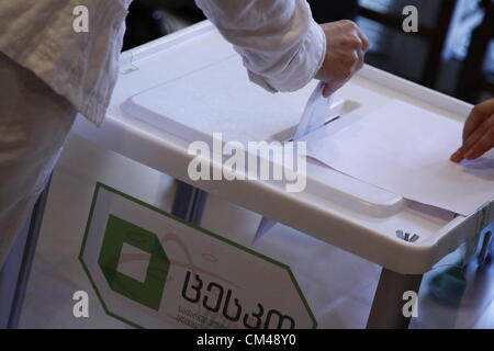 1 Ottobre 2012 - Tibilisi, Georgia - slittamento degli elettori la busta con il voto cartaceo in urne. La scatola è contrassegnata con il logo della Georgian Commissione elettorale centrale. Credito: Johann Brandstatter / Alamy Live News Foto Stock