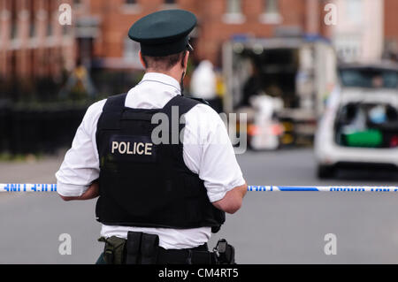 Belfast, Irlanda del Nord, Regno Unito. Il 4 ottobre 2012. PSNI ufficiali vicino Jamaica Street nella zona di Ardoyne di Belfast dopo il sospetto di una bomba è stata scoperta durante un progetto di ricerca di una casa. Circa 30 case sono state evacuate, e l'esercito ATOs erano chiamati a rendere il dispositivo di sicura. Foto Stock