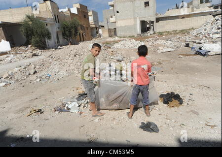 Azaz, Siria. Il 5 ottobre 2012. La vita dei bambini che sono in qualche modo cercando disperatamente di rimanere vivo e crescere in mezzo alla carneficina e caos attorno a loro é pur conservando la loro ebullience ad essere bambini ! AZAZÑIn Siria settentrionale, il 15 agosto almeno 80 persone sono state uccise in un'zaz come risultato del bombardamento aereo dai siriani Air Force Base di attivisti dell'opposizione e medici locali. Foto Stock