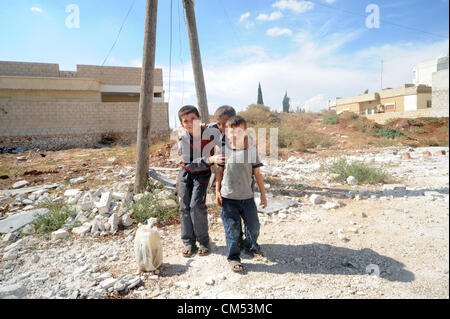 Azaz, Siria. Il 5 ottobre 2012. La vita dei bambini che sono in qualche modo cercando disperatamente di rimanere vivo e crescere in mezzo alla carneficina e caos attorno a loro é pur conservando la loro ebullience ad essere bambini ! AZAZÑIn Siria settentrionale, il 15 agosto almeno 80 persone sono state uccise in un'zaz come risultato del bombardamento aereo dai siriani Air Force Base di attivisti dell'opposizione e medici locali. Foto Stock