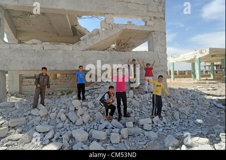 Azaz, Siria. Il 5 ottobre 2012. La vita dei bambini che sono in qualche modo cercando disperatamente di rimanere vivo e crescere in mezzo alla carneficina e caos attorno a loro é pur conservando la loro ebullience ad essere bambini ! AZAZÑIn Siria settentrionale, il 15 agosto almeno 80 persone sono state uccise in un'zaz come risultato del bombardamento aereo dai siriani Air Force Base di attivisti dell'opposizione e medici locali. Foto Stock