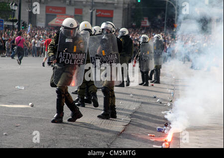 Atene, Grecia. Martedì 09 ottobre 2012 nell'immagine: polizia sono stati gettati flares dai manifestanti in piazza Syntagma, davanti al parlamento greco. Re: il Cancelliere tedesco Angela Merkel ha promesso il suo paese continuerà a fornire appoggio alla Grecia, durante la sua prima visita ad Atene dal momento che la zona euro crisi scoppiata a quasi tre anni fa. La signora Merkel ha detto la Grecia aveva compiuto buoni progressi nel trattare con il suo vasto debito ma che era su un "difficile percorso'. Migliaia di persone che la colpa della Germania per forzare dolorose misure di austerità in Grecia stanno protestando in Atene. La polizia ha usato gas lacrimogeni e st Foto Stock