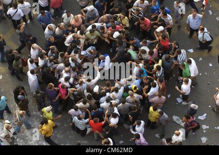 Ottobre 13, 2012 - Cairo, Egitto - Egyptian pro-governo manifestanti si radunano attorno a un uomo ferito durante i violenti scontri contro il governo anti-manifestanti in piazza Tahrir il Venerdì, 12 ottobre 2012. La violenza è scoppiata mentre la Fratellanza Musulmana protestava per la giustizia per i martiri della rivoluzione e l opposizione è stata protestando contro la Fratellanza Musulmana governo dominato. (Credito Immagine: © Cliff Cheney/ZUMAPRESS.com) Foto Stock