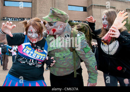 Londra, Regno Unito. 13/10/12. Zombie orda rampages intorno alla Tate Modern sulla banca del sud. Non sono solo gli zombie su una sanguinosa sete di ricerca di carne umana, essi sono anche la raccolta di fondi per l'evento ha scelto la carità, St Mungos. Più di 50 città in tutto il mondo a partecipare al Mondiale Zombie giorno, tra cui New York, Pittsburgh, Parigi, Hong Kong, Los Angeles, Chicago, Dallas, Seattle, e Tokyo. Foto Stock