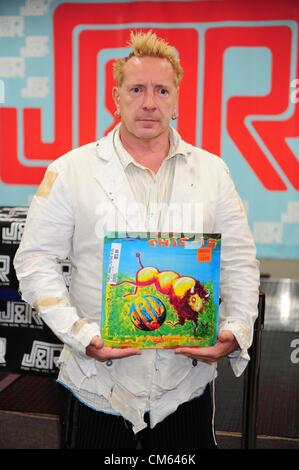 Ottobre 13, 2012 - Manhattan, New York, Stati Uniti - JOHN LYDON segni di copie del nuovo record immagine pubblica Ltd.: Questo è il Pil e altri cimeli del PIL in J&R Musica di Manhattan il 13 ottobre 2012. La SIF sta eseguendo questa sera presso la sala da ballo Hammerstein. (Credito Immagine: © Bryan Smith/ZUMAPRESS.com) Foto Stock