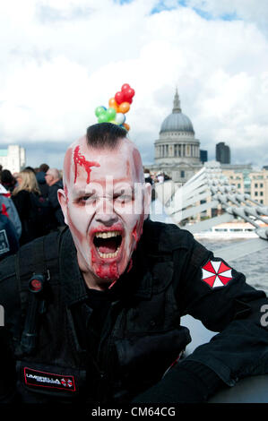 Londra, Regno Unito. 13/10/12. Zombie orda rampages intorno alla Tate Modern sulla banca del sud. Non sono solo gli zombie su una sanguinosa sete di ricerca di carne umana, essi sono anche la raccolta di fondi per l'evento ha scelto la carità, St Mungos. Più di 50 città in tutto il mondo a partecipare al Mondiale Zombie giorno, tra cui New York, Pittsburgh, Parigi, Hong Kong, Los Angeles, Chicago, Dallas, Seattle, e Tokyo. Foto Stock