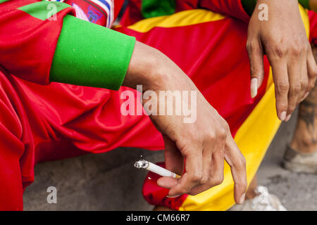 Ottobre 14, 2012 - Bangkok, Tailandia - un uomo detiene una sigaretta mentre si fuma in una strada a Bangkok, Thailandia. La Tailandia e le filippine sono coinvolti in una disputa sulle tasse di sigaretta. Philippine scambi funzionari affermano che la Thailandia tariffe sleali una tassa di importazione sui Filippini di sigarette. Funzionari tailandesi hanno risposto che essi hanno preso la materia oggetto della consulenza. Philippine hanno detto i funzionari possono portare la questione all'Organizzazione mondiale del commercio se la Tailandia non risponde da ott. 15. (Credito Immagine: © Jack Kurtz/ZUMAPRESS.com) Foto Stock