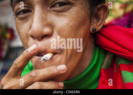 Ottobre 14, 2012 - Bangkok, Tailandia - un uomo fuma una sigaretta in una strada a Bangkok, Thailandia. La Tailandia e le filippine sono coinvolti in una disputa sulle tasse di sigaretta. Philippine scambi funzionari affermano che la Thailandia tariffe sleali una tassa di importazione sui Filippini di sigarette. Funzionari tailandesi hanno risposto che essi hanno preso la materia oggetto della consulenza. Philippine hanno detto i funzionari possono portare la questione all'Organizzazione mondiale del commercio se la Tailandia non risponde da ott. 15. (Credito Immagine: © Jack Kurtz/ZUMAPRESS.com) Foto Stock