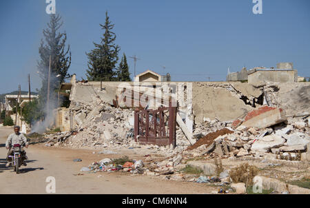 Azaz, Siria. Il 17 ottobre 2012. Un uomo corse da un edificio distrutto da un caccia attentato in un'zaz, Siria il 17 ottobre 2012. Credito: PixelPro / Alamy Live News Foto Stock