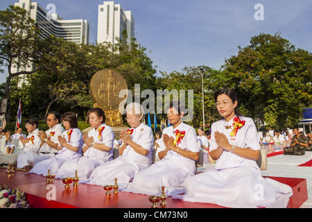 20 ott. 2012 - Bangkok, Thailandia - Le donne portano una preghiera per la pace nel sud della Thailandia durante una speciale alms dando una cerimonia in Bangkok. Più di 2.600 i monaci buddisti di tutta Bangkok e migliaia di devoti buddisti tailandesi hanno partecipato alla santa Messa alms cerimonia nel Parco di Benjasiri a Bangkok il sabato mattina. La cerimonia è stata per sollevare il cibo e le erogazioni liberali in denaro per i templi buddisti in Thailandia del violenza afflitto province meridionali. A causa del continuo di lunga esecuzione insurrezione dai separatisti musulmani molti monaci buddisti in Pattani, Narathiwat e Yala, Thailandia del tre maggioranza musulmana province, Foto Stock