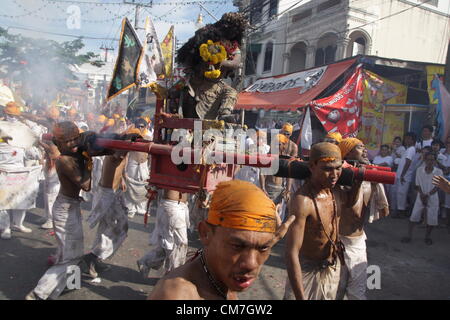 21,10,2012. Phuket , della Thailandia . Portando un idolo su un palanquin durante una processione di strada.Il Phuket Vegetarian Festival inizia la prima sera del nono mese lunare e dura nove giorni, religiosi devoti slash stessi con le spade, Pierce loro guance con oggetti appuntiti e commettere altri atti dolorosi per purificarsi Foto Stock