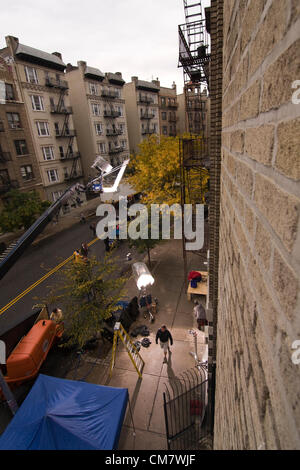 New York, Stati Uniti d'America. Il 23 ottobre 2012. O pellicole positive. Vista aerea di due grossi proiettori illuminando la posizione sul set di un film mentre gli spettatori guarda la troupe cinematografica lavorando su Wadsworth Avenue nel quartiere Inwood di Manhattan a New York City Foto Stock