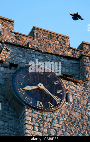 27 Ottobre 2012 - Mumbles - Swansea - REGNO UNITO : la luce calda di sunrise brilla sul vecchio orologio sulla torre normanna della chiesa di Tutti i Santi nel piccolo villaggio di pescatori di Mumbles vicino a Swansea in Galles del Sud presto su un nitido mattina autunnale. Questa sera nelle prime ore della mattinata di domenica, gli orologi torna indietro, che scandisce la fine del periodo estivo britannico per il 2012. Foto Stock