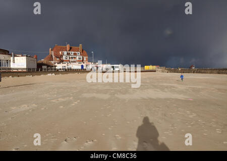 Gorleston-on-Sea, Norfolk, Regno Unito. Il 27 ottobre 2012. Un piccolo ragazzo corre per coprire da la grandinata di avvicinamento Foto Stock