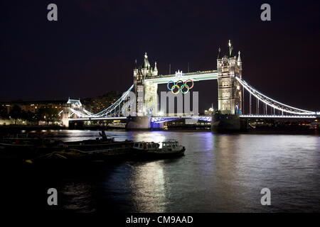 Londra, Regno Unito. Il 27 giugno 2012. Giant anelli olimpici sul ponte della torre per contrassegnare il conto alla rovescia per il London 2012 giochi. Gli anelli, 25 metri di larghezza e 11,5 metri, sono stati abbassati in posizione sulla centrale del simbolo di Londra sul Fiume Tamigi con la raccolta pubblica sul fiume nel percorso di luce della sera. Gli anelli, che pesano tre tonnellate, costo £259,817 per produrre e la loro installazione è stimato per un costo di £ 53.000. Foto Stock