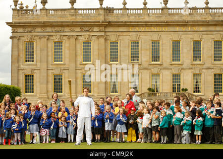 Derbyshire, Regno Unito. Venerdì 29 Giugno 2012. Torcia olimpica bearer, ben sperare con il Duca e la Duchessa di Devonshire e i ragazzi della scuola media locale sulla South Lawn di Chatsworth House. Chatsworth House è la sede del duca di Devonshire ed è stata la residenza della famiglia Cavendish fin dal 1549. Foto Stock