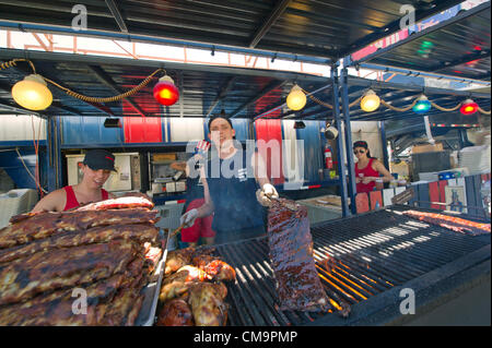 Toronto, Canada. Il 30 giugno 2012, un venditore dimostra la sua arte di grigliare costolette di maiale durante il Toronto ribfest. Il festival ha attirato i punteggi di Torontonians al Centennial Park motivi durante il lungo weekend che ha segnato il Canada Day celebrato il 1 di luglio. Foto Stock