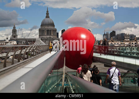 Il Millennium Bridge a Londra il 30 giugno 2012 dove la grande sfera rossa progetto arriva causando un sacco di interesse. Il progetto è stato in varie posizioni di Londra tutto intorno alla zona del Tamigi. Ha fatto una comparsa in Covent Garden è stato quindi visto su tre dei ponti nei pressi del Southbank. È il lavoro di un artista Kurt Perschke. Foto Stock