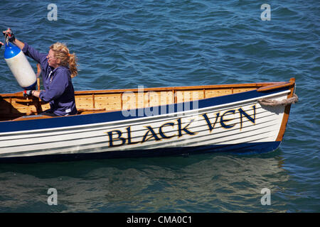 Weymouth, Dorset UK sabato 30 giugno 2012. Weymouth Rowing Regatta - squadre in gara in Cornish Pilot Gigs. Donna che tiene il parafango in Black Ven Foto Stock