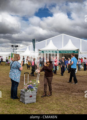 Hampton Court,UK. Mercoledì 4 luglio 2012 visitatori potrete gustare un gelato al di fuori di Floral Marquee all'Hampton Court Palace Flower Show. Questa è la più grande fiera dei fiori in tutto il mondo e si tiene ogni anno nel mese di luglio. Esso è gestito dalla Royal Horticultural Society e viene eretto sui lati nord e sud della lunga acqua a Hampton Court Palace. Il primo spettacolo è stato nel 1990. Foto Stock