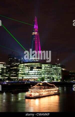 Londra, Inghilterra, Regno Unito. Giovedì 5 luglio 2012. La luce laser show per contrassegnare il completamento delle opere esterne sulla Shard. Illuminata da una selezione di 12 laser e 30 luci di ricerca trasmissione via IR tra lo skyline, raggiungere fuori ad altri punti di riferimento. Situato sul fiume Tamigi a Southwark, il grattacielo sarà completamente illuminata. Foto Stock