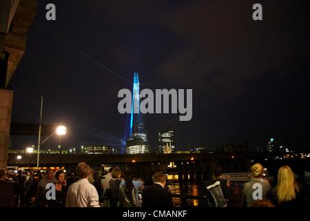 Londra REGNO UNITO. Giovedì 5 luglio 2012. Dodici i laser e i proiettori 30 illuminato il cielo notturno, per festeggiare il completamento esterno del coccio. Esso è il più alto edificio in Europa, a 95 piani a 1,016ft alta. Laser a colori e di flussi di luce proiettato fuori dal Shard su London Southbank riflettente nel fiume Tamigi il 6 luglio. Foto Stock