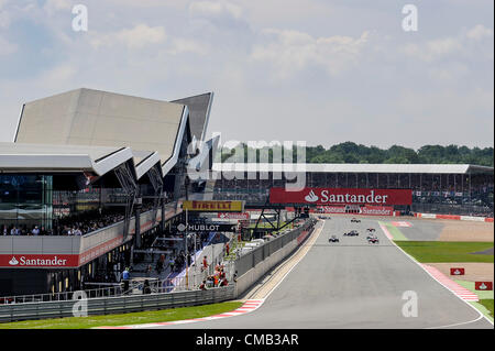 08.07.2012 Towcester, Inghilterra. Il campo guidato da Fernando Alonso della Spagna e la Scuderia Ferrari e Mark Webber di Australia e la Red Bull Racing completare la bandiera verde giro durante la gara a Santander British Grand Prix, Round 9 del 2012 FIA del Campionato del Mondo di Formula 1 sul circuito di Silverstone. Foto Stock