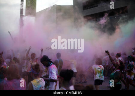 IOWA (USA). Domenica 8 luglio 2012. Color Me Rad gara i partecipanti sono coperti in una nuvola di polvere colorata coloranti durante il gruppo finale "bombardamenti di colore' in Council Bluffs, Iowa gara. Color Me Rad combina un 5K run/a piedi con essere irrorato con amido di mais colorati e colorante e vantaggi le Olimpiadi speciali. Foto Stock