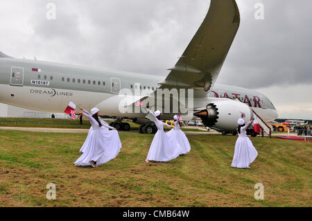 Farnborough, Regno Unito. Lunedì 9 luglio 2012. Qatar Airways ballerini danza attorno al piano noi maker Boeing 787 jet 'Dreamliner' al Farnborough International Airshow 2012 che ha inizio oggi. Si è visto come un rivale di Airbus europei al salone di Farnborough. Qatar Airways ha partecipato per la prima volta a battenti visualizza a Farnborough Airshow internazionale. Foto Stock