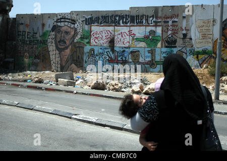 9 luglio 2012 - Ramallah, West Bank, Territorio palestinese - Una donna Palestinese passeggiate oltre il muro di separazione tra Ramallah e Gerusalemme, 9 luglio 2012. Otto anni fa, precisamente nel 2004, ha preso la Corte internazionale di giustizia, braccio giudiziario statuto delle Nazioni Unite, in base all'Aia nei Paesi Bassi, una risoluzione advisory, servendo la condanna e la criminalizzazione di espansione e la parete di annessione di razza Israele iniziò la costruzione in Cisgiordania, durante il governo di Ariel Sharon nel mese di giugno 2002, nonché l'insediamento israeliano in tutte le sue forme, è illegale un Foto Stock