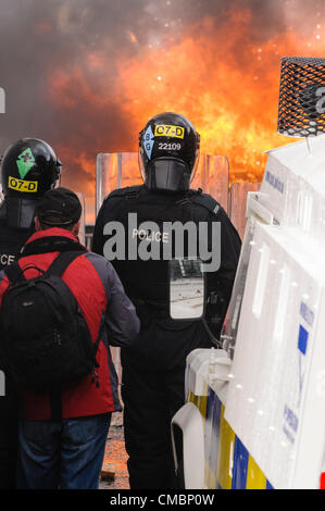 Belfast, 12/07/2012 - un'auto è impostato sul fuoco e spinto verso le linee di polizia come la violenza scoppia in Ardoyne 12 luglio successivo ordine arancione parade Foto Stock