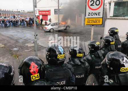 Belfast, 12/07/2012 - un'auto è impostato sul fuoco e spinto verso le linee di polizia come la violenza scoppia in Ardoyne 12 luglio successivo ordine arancione parade Foto Stock